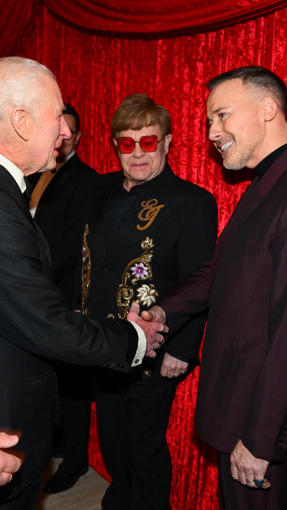 Elton y su marido, David Furnish, saludando al rey Carlos III.