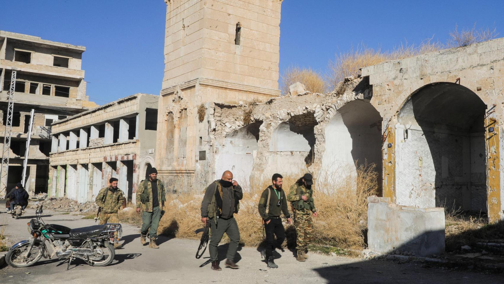 Rebeldes caminan en Maarat al-Numan en la provincia de Idlib, Siria.