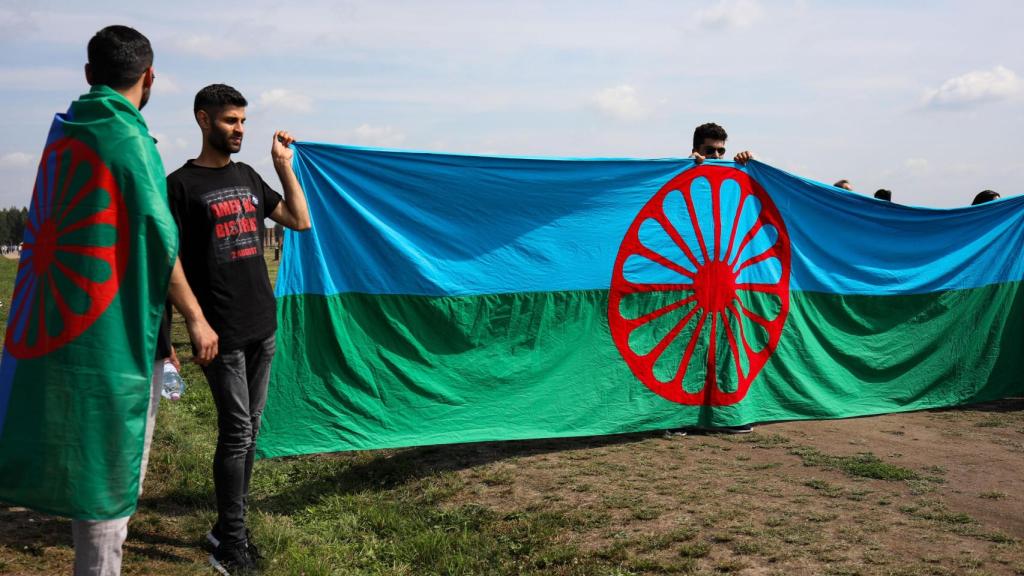 Varias personas muestran la bandera gitana