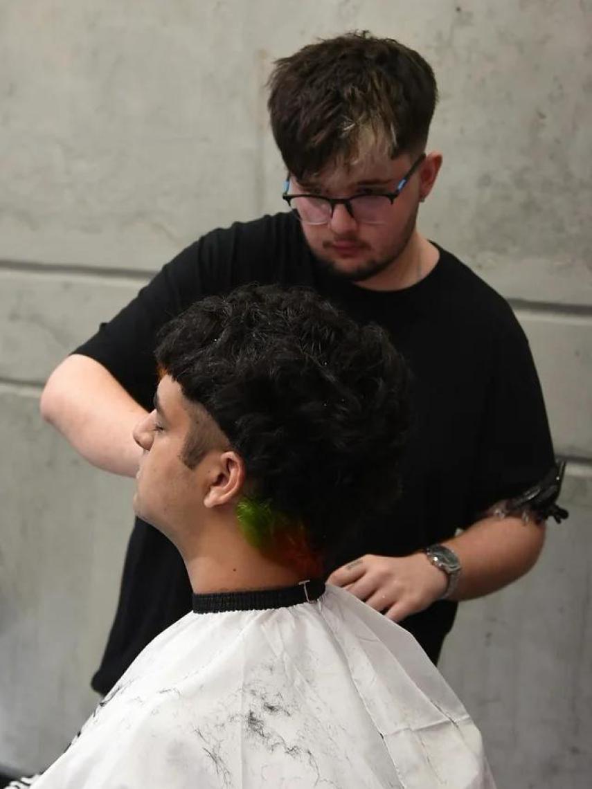 El emprendedor Christian Martín realiza un corte de cabello.