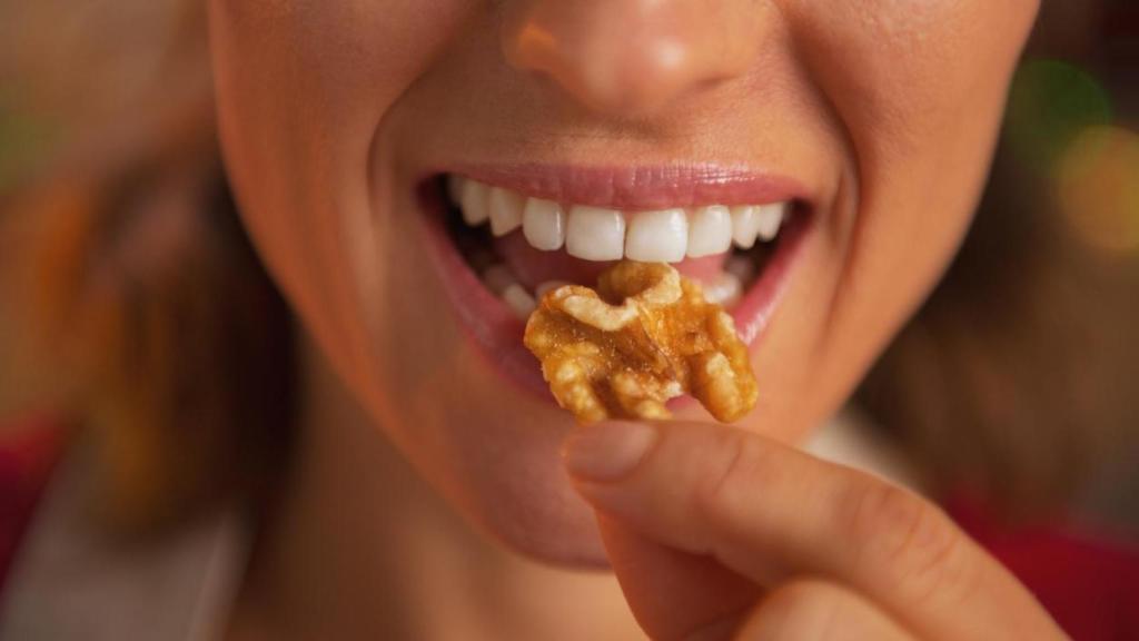 Mujer comiendo una nuez.