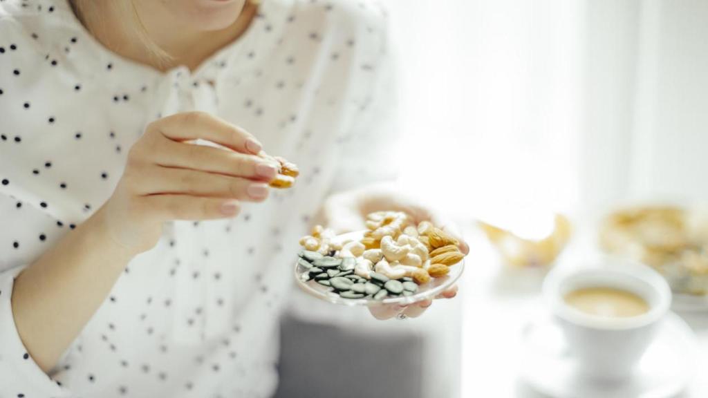 Mujer comiendo frutos secos.