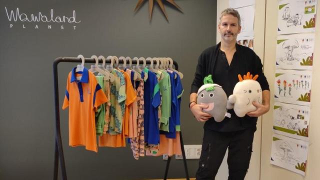 Ton Pernas, con peluches de los personajes de 'Los Wawies' ante bocetos de la serie y prendas de su colección de moda infantil Wawaland.