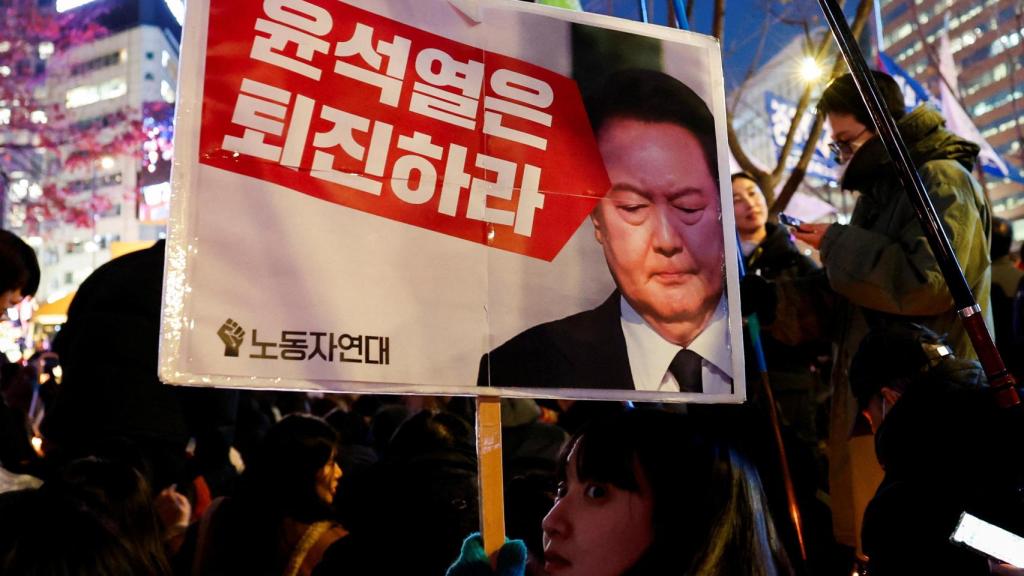 Una manifestante con un cartel que pide la dimisión del presidente de Corea del Sur Yoon Suk-yeol.