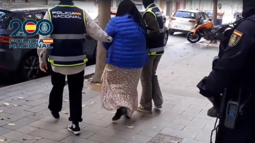 La detenida, saliendo de su casa con la Policía Nacional.