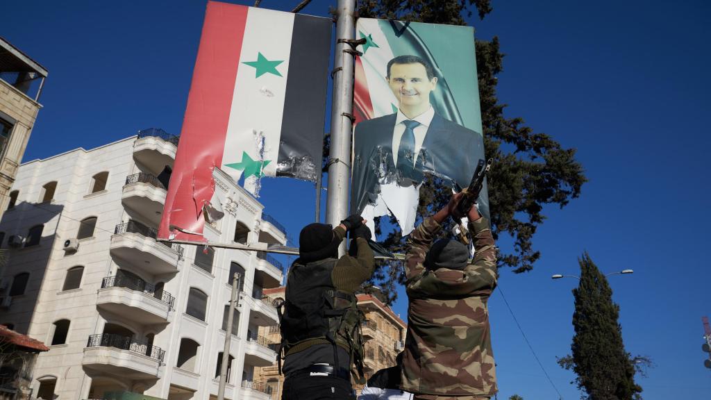 Combatientes de la oposición siria rompen un retrato del presidente sirio Bashar al-Assad en el centro de Alepo, Siria, el 30 de noviembre de 2024.