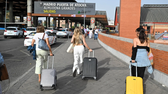 Varias personas con sus maletas a su llegada a la estación de Atocha de Madrid