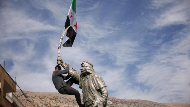 Un hombre se sube a una escultura del sultán Pasha al Atrash, un guerrero druso que lideró una revuelta contra el dominio francés en 1925.