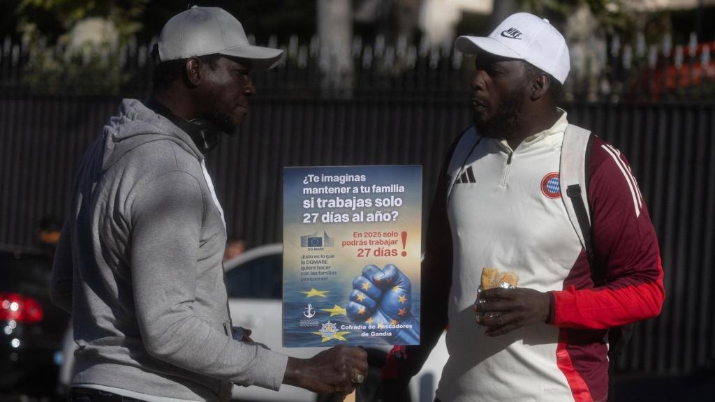 Dos pescadores del litoral mediterráneo con un cartel durante una concentración frente a la sede de la Comisión Europea, a 9 de diciembre de 2024, en Madrid (España). Los pescadores han protestado contra la propuesta que recorta los días en el mar para los barcos arrastreros un 79%, hasta una media de 27 días de pesca al año, y que se negocia desde ayer en Bruselas.