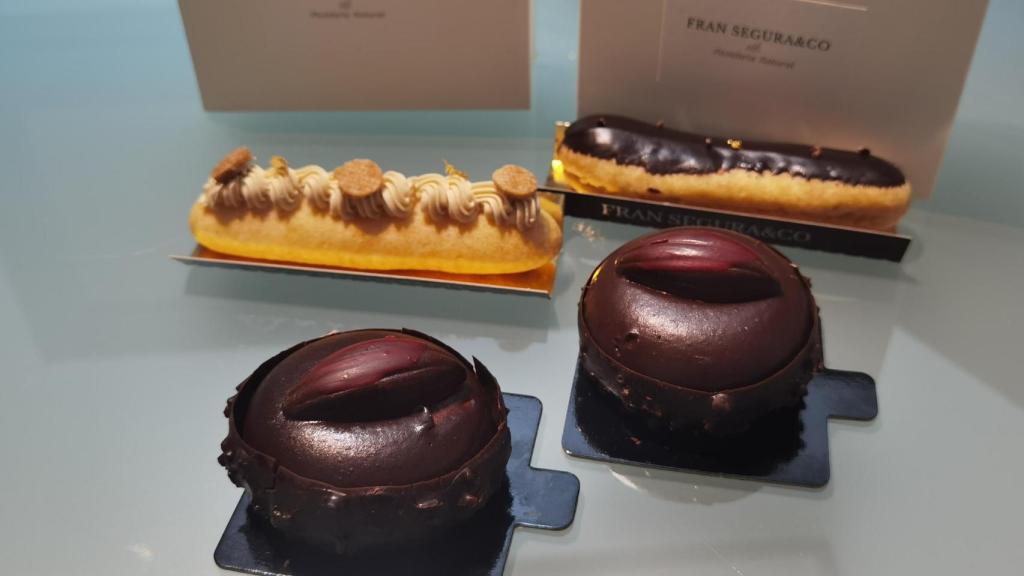 Las tartas de chocolate y dos de los éclair que prepara Fran Segura en Alicante.