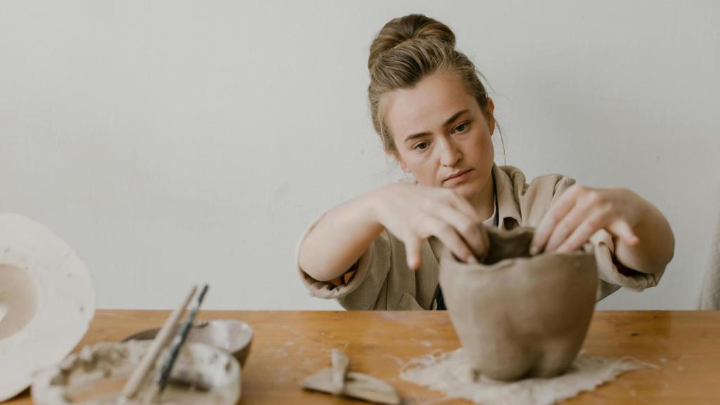 Mujer trabajando una pieza de cerámica