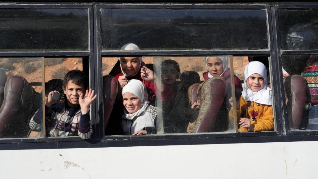 Un autobús lleno de niños y niñas, en un puesto fronterizo entre Líbano y Siria.