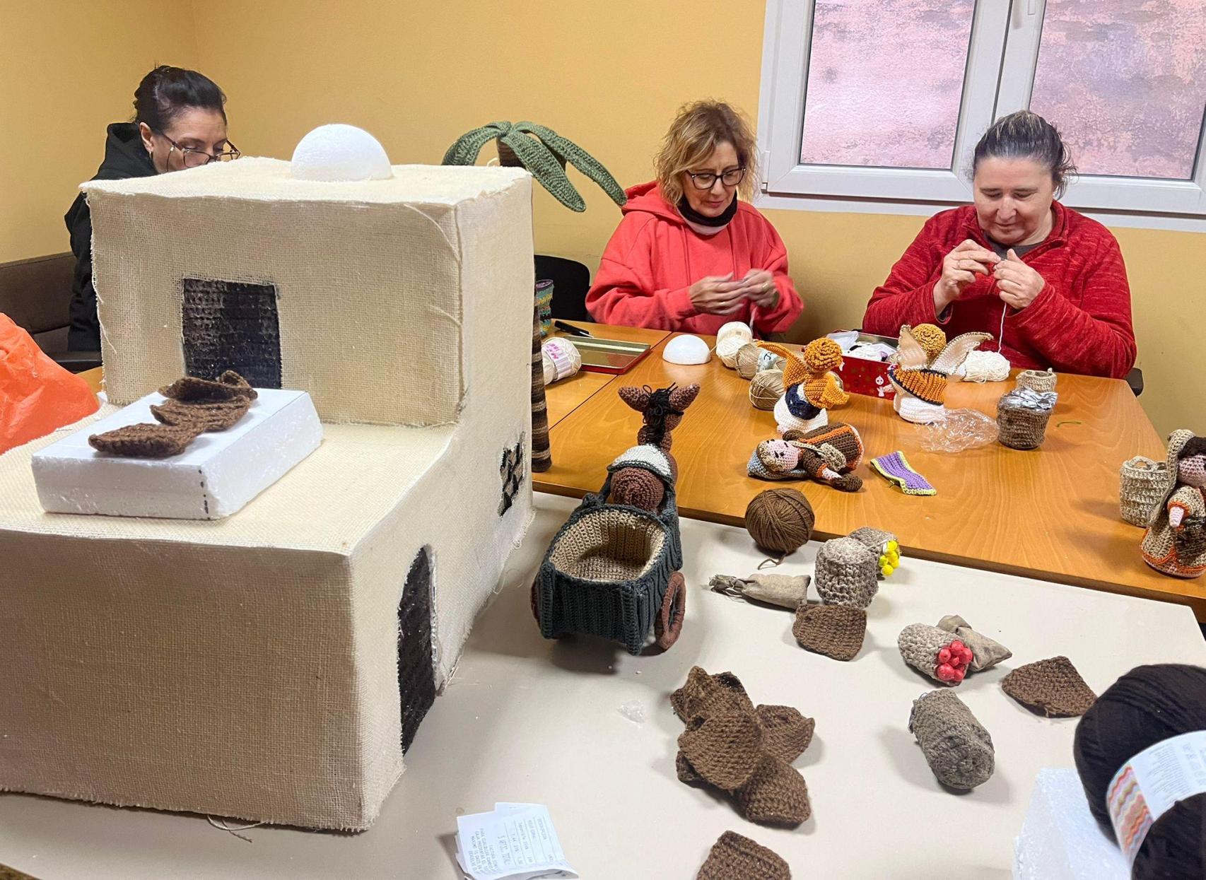 Un grupo de mujeres tejedoras elaborando las figuras del belén