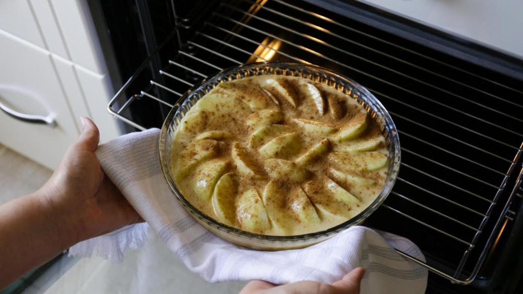 Introduciendo una tarta de manzana en el horno.