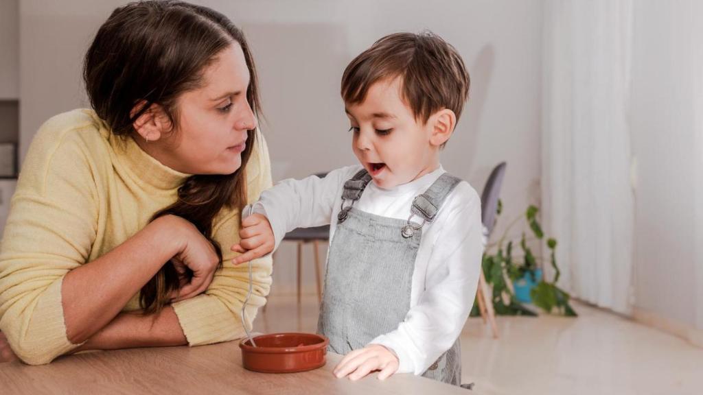 Madre junto a su hijo mientras come.