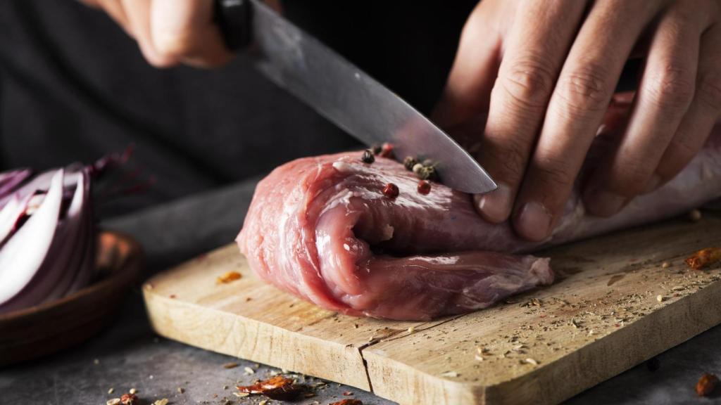 Una persona corta una pieza de carne