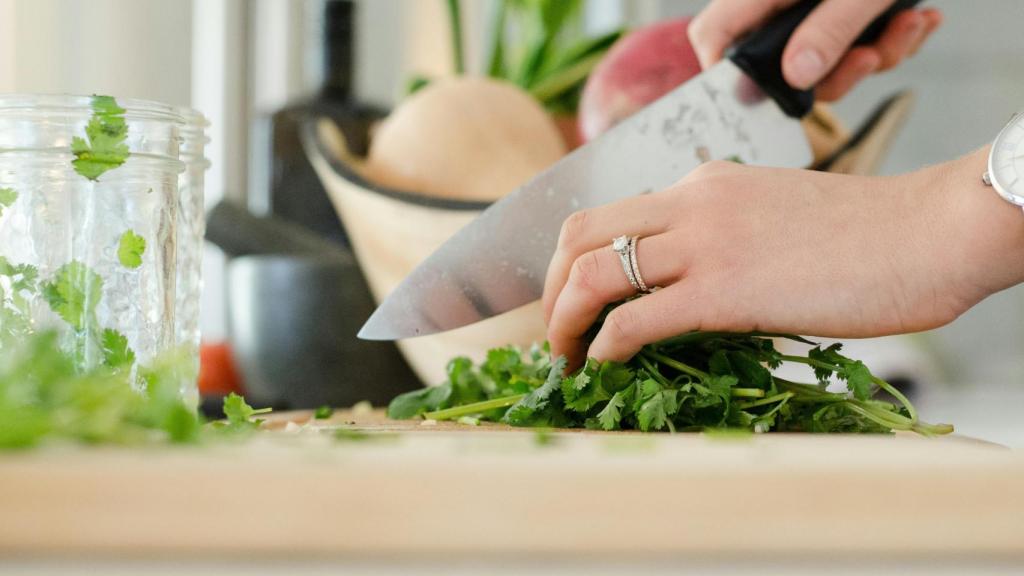 Una mano cortando verduras, en una imagen de archivo.