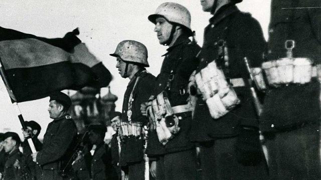 Soldados de la División Azul formando junto a la bandera española en el puesto de mando de Prokrowskaja.