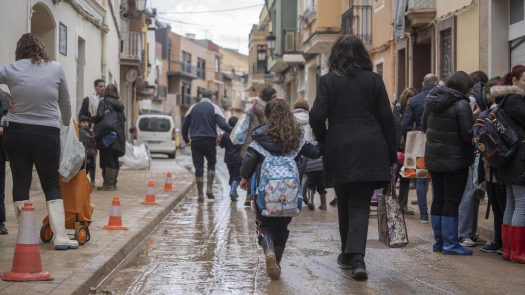 Una niña con su madre sale de un colegio en Paiporta