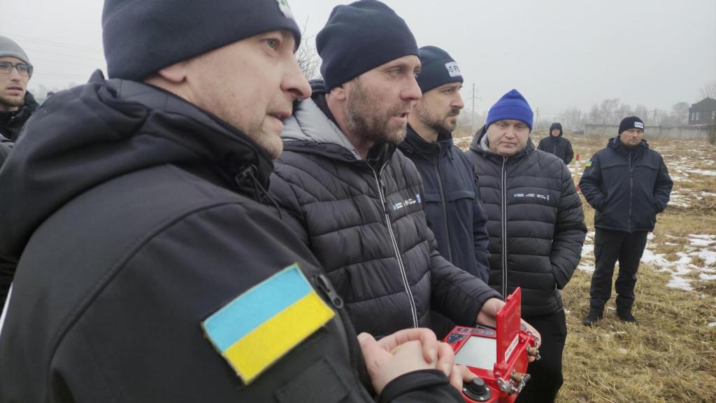 En un campo nevado de la región de Cherníguiv veteranos de guerra ucranianos con discapacidades o mutilaciones reciben instrucción en el manejo de vehículos de desminado.