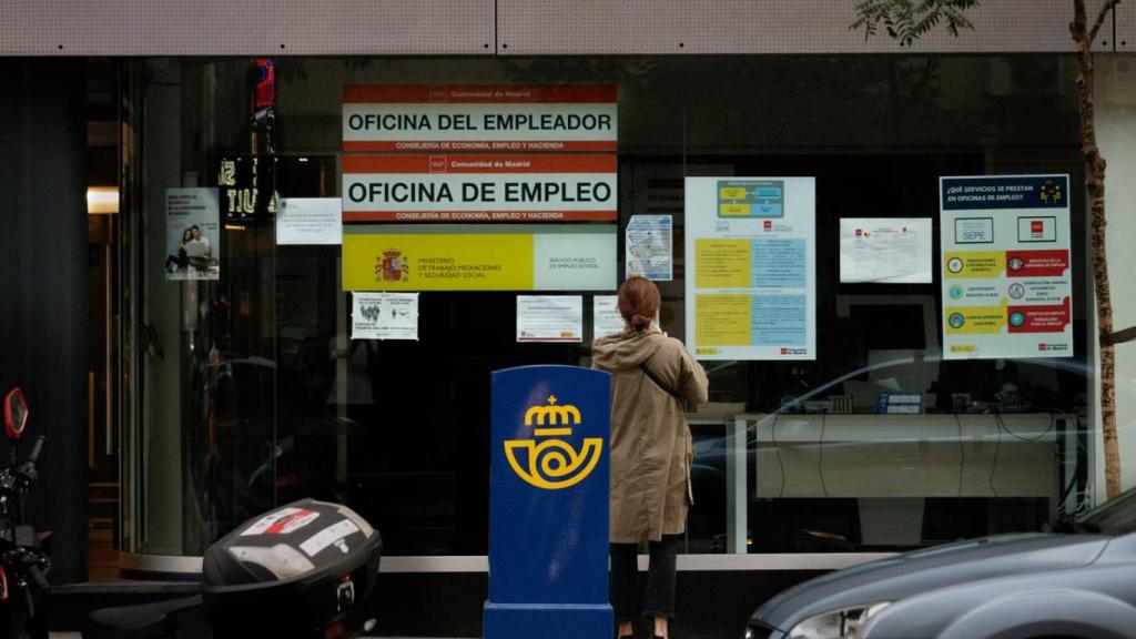 Imagen de una mujer frente a una oficina de empleo.