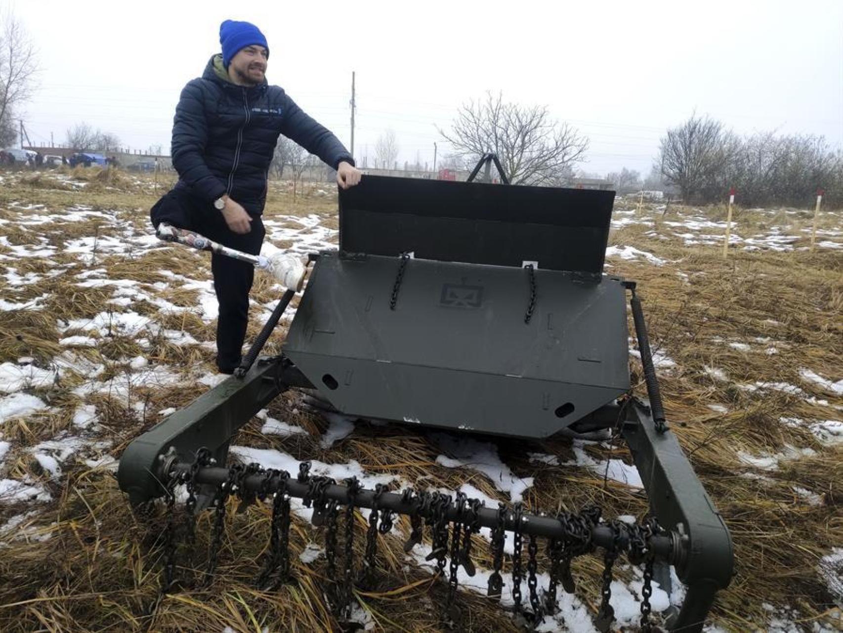 En un campo nevado de la región de Cherníguiv veteranos de guerra ucranianos con discapacidades o mutilaciones reciben instrucción en el manejo de vehículos de desminado.