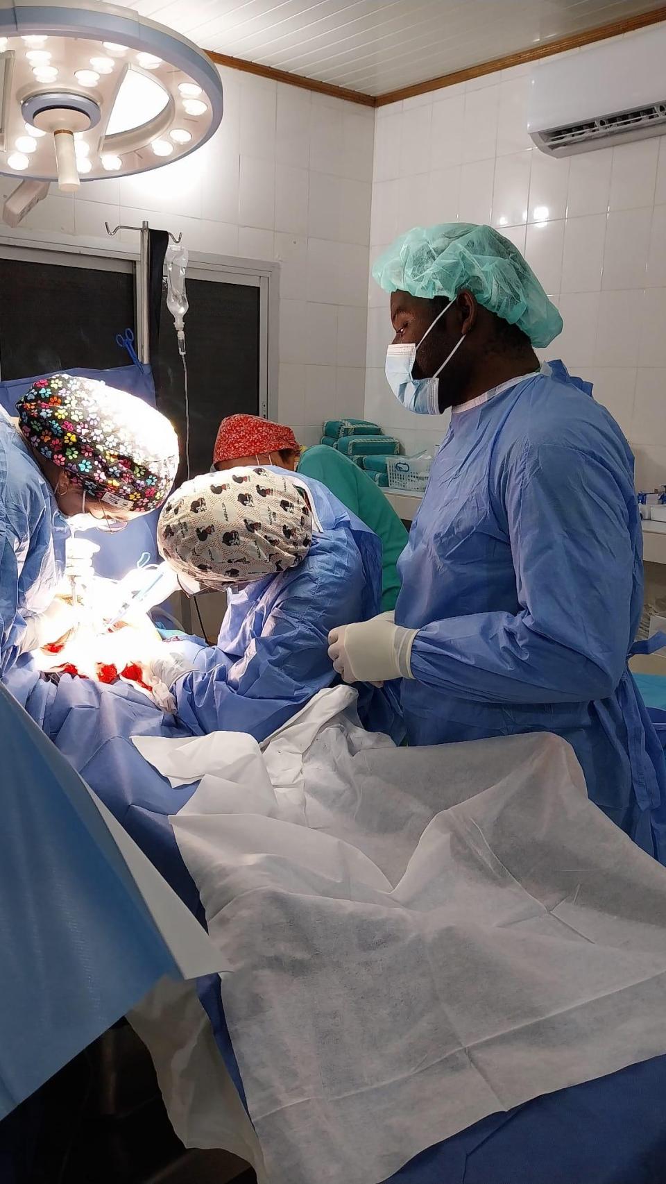 Equipo médico local y de médicas voluntarias durante una cirugía.
