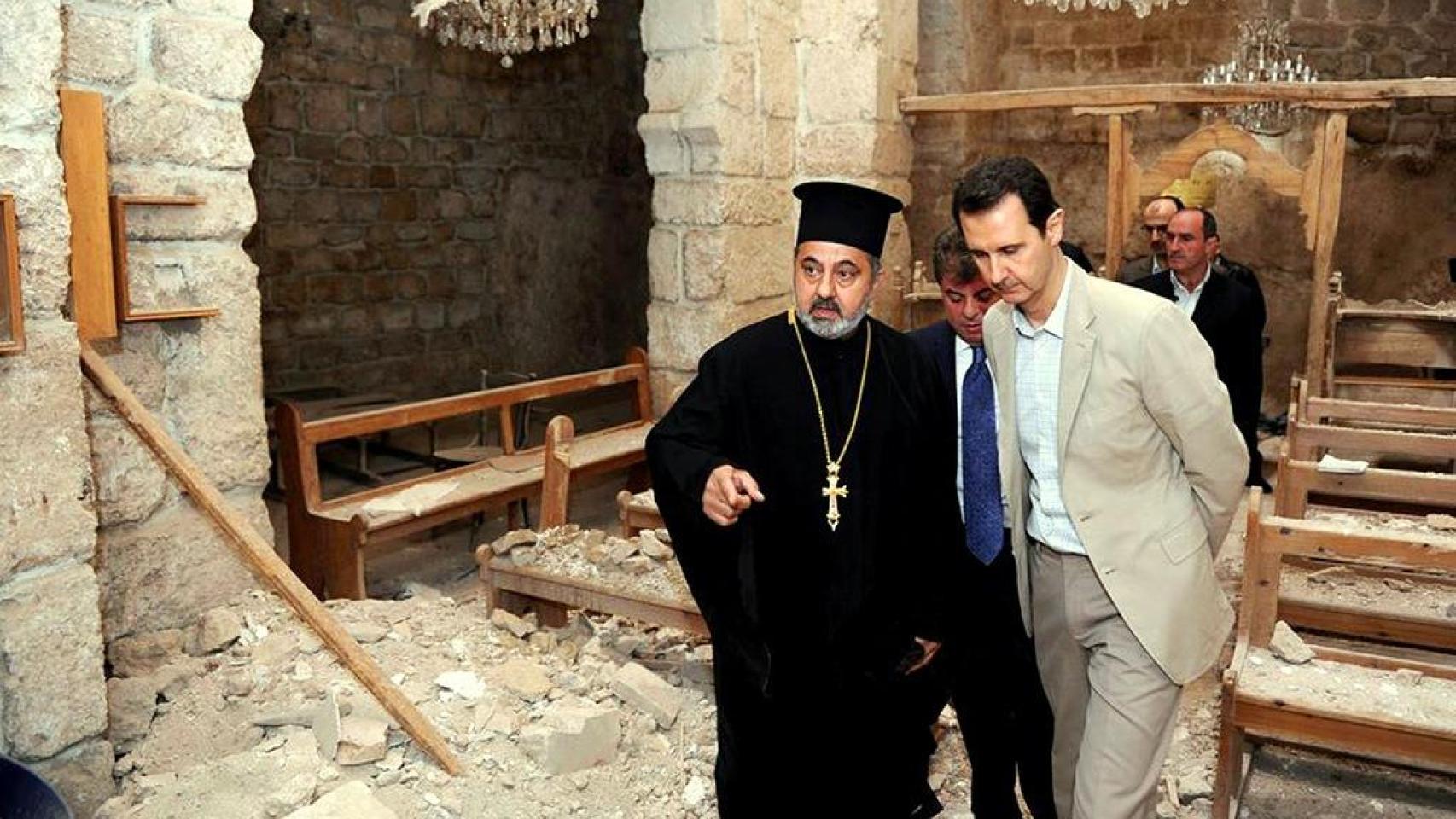 El presidente Bashar al-Assad en una iglesia dañada por rebeldes sirios durante una visita a la aldea cristiana Maaloula, al lado de Damasco, en abril de 2014