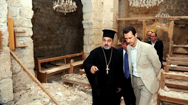 El presidente Bashar al-Assad en una iglesia dañada por rebeldes sirios durante una visita a la aldea cristiana Maaloula, al lado de Damasco, en abril de 2014