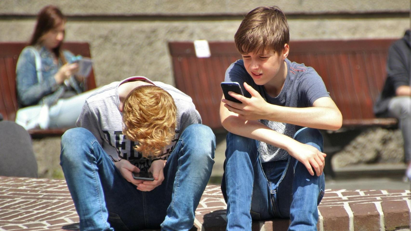 Dos jóvenes con smartphones.