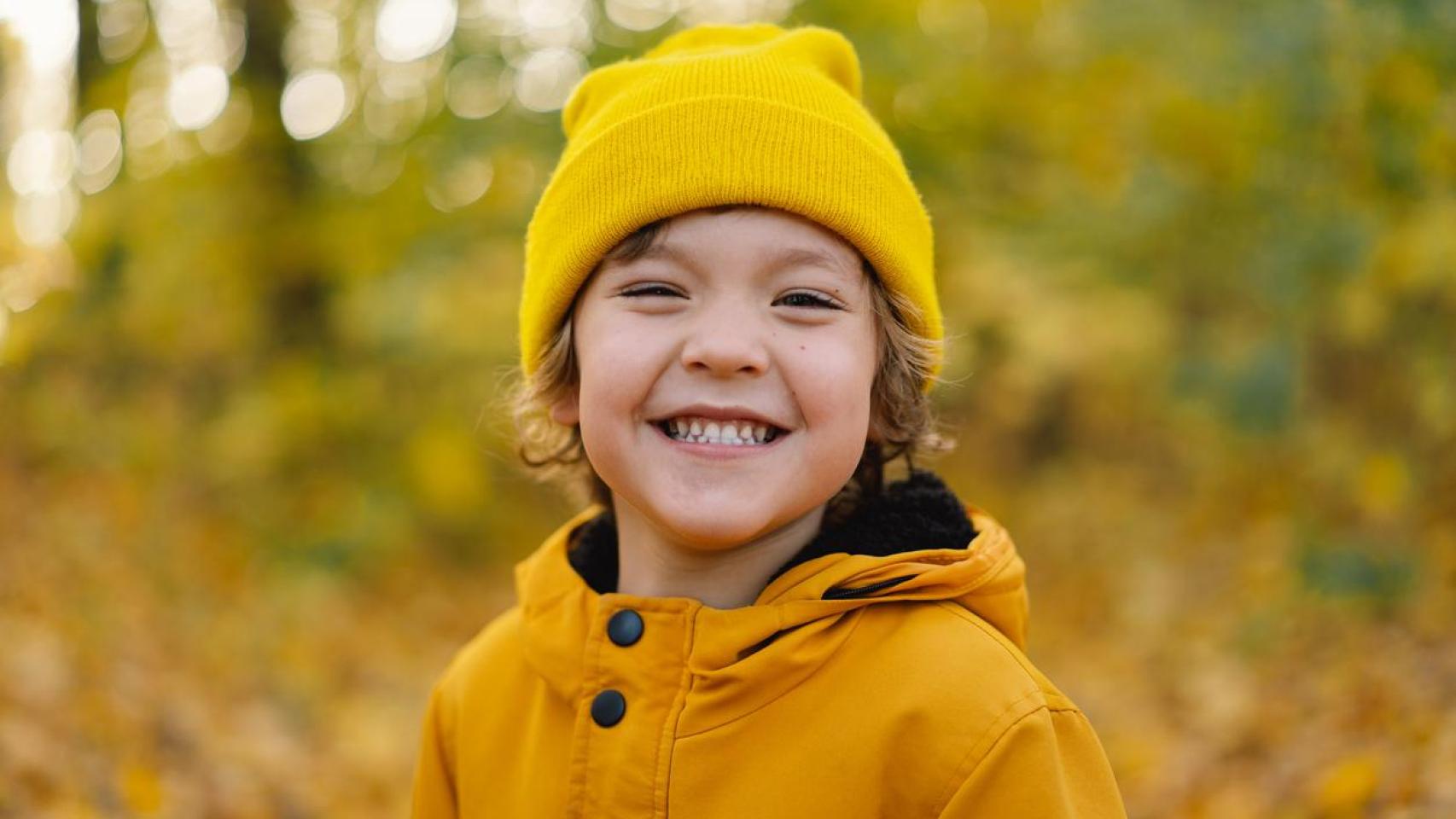 Un niño con gorro en la naturaleza.