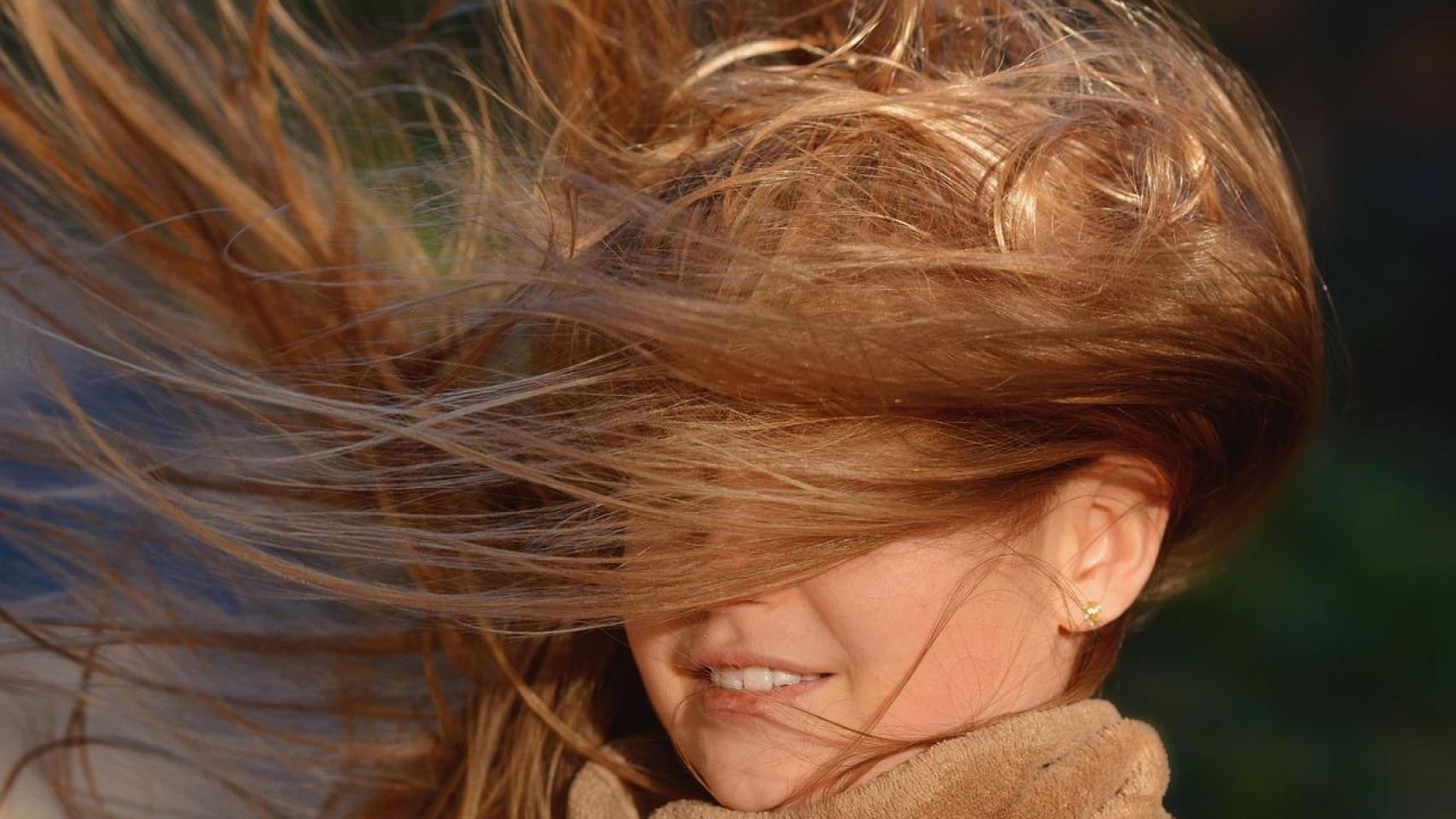 Una niña con el pelo alborotado por el viento.