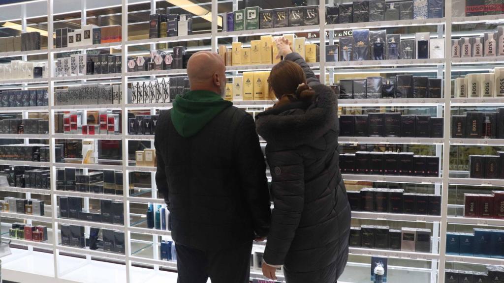 Dos personas mirando productos cosméticos en la nueva tienda.