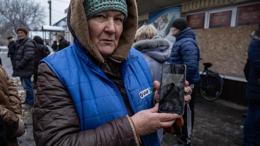 Valentina, una residente de Pokrovsk, muestra en su teléfono la foto de su casa, que ha sido parcialmente bombardeada por las tropas rusas