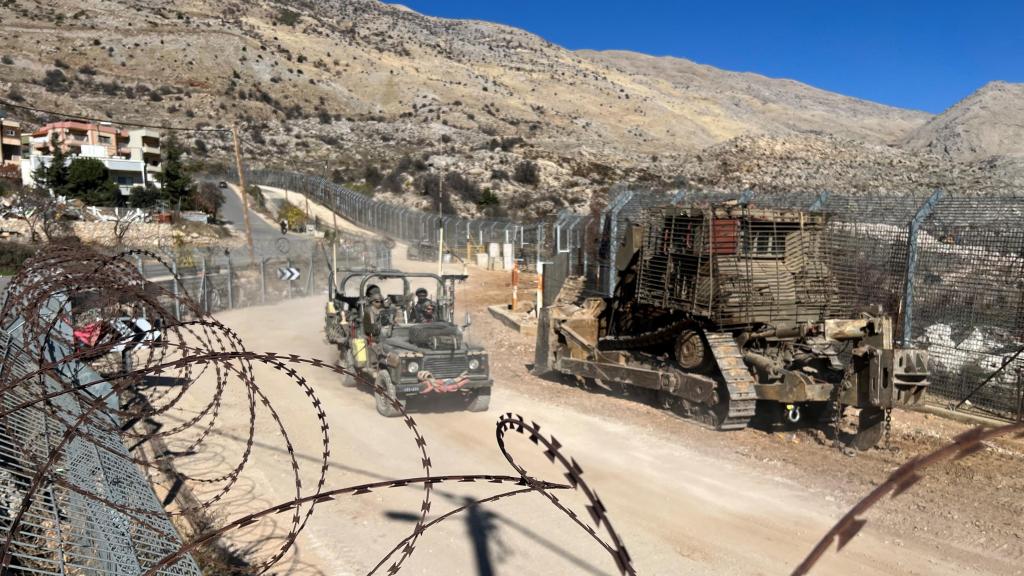 Soldados israelíes viajan en un vehículo militar a lo largo de la línea de alto el fuego con Siria y los Altos del Golán ocupados por Israel, visto desde los Altos del Golán, el 15 de diciembre de 2024.