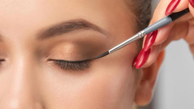 Mujer pintándose el eyeliner.