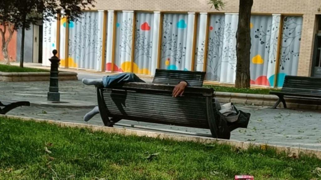 Un hombre durmiendo en un banco de la zona.