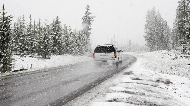 Un coche por una carretera nevada.