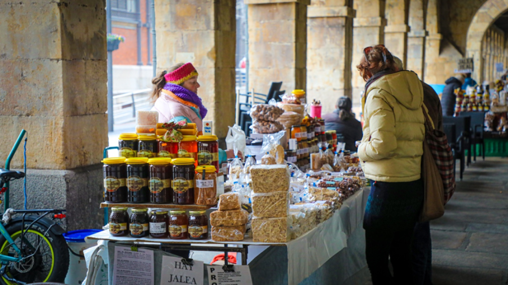 Dos turistas franceses adquiriendo los productos artesanos en la Plaza del Mercado | Luis Cotobal