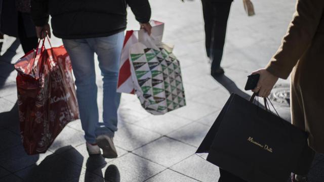 Varias personas con bolsas de la compra en una calle céntrica de Sevilla.