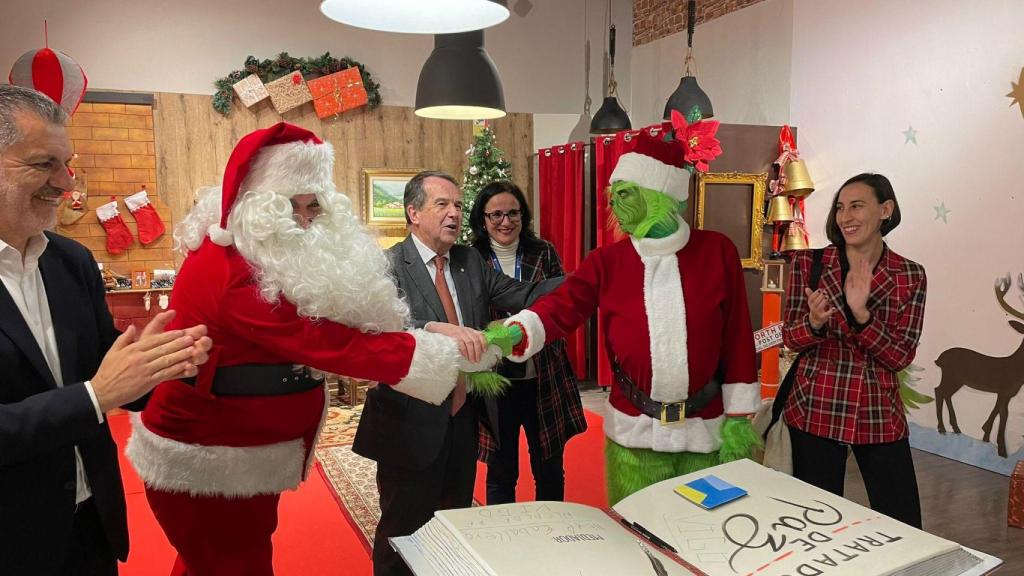 Papá Noel y El Grinch se dan la mano.