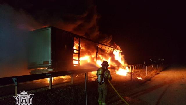 Un bombero sofocando las llamas del camión