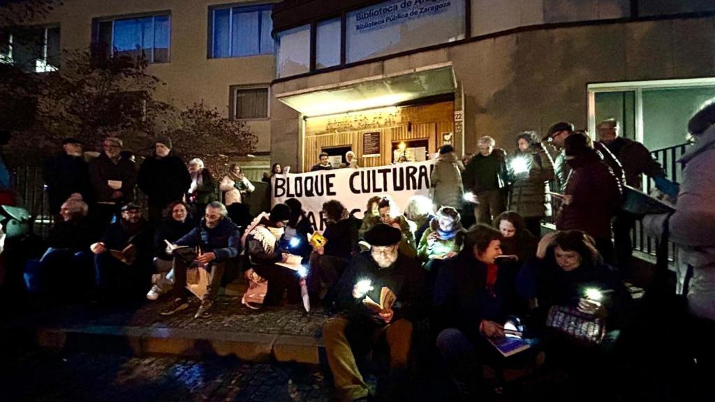 Algunos zaragozanos leyendo a las puertas de la Biblioteca Pública de Aragón como protesta por su cierre.