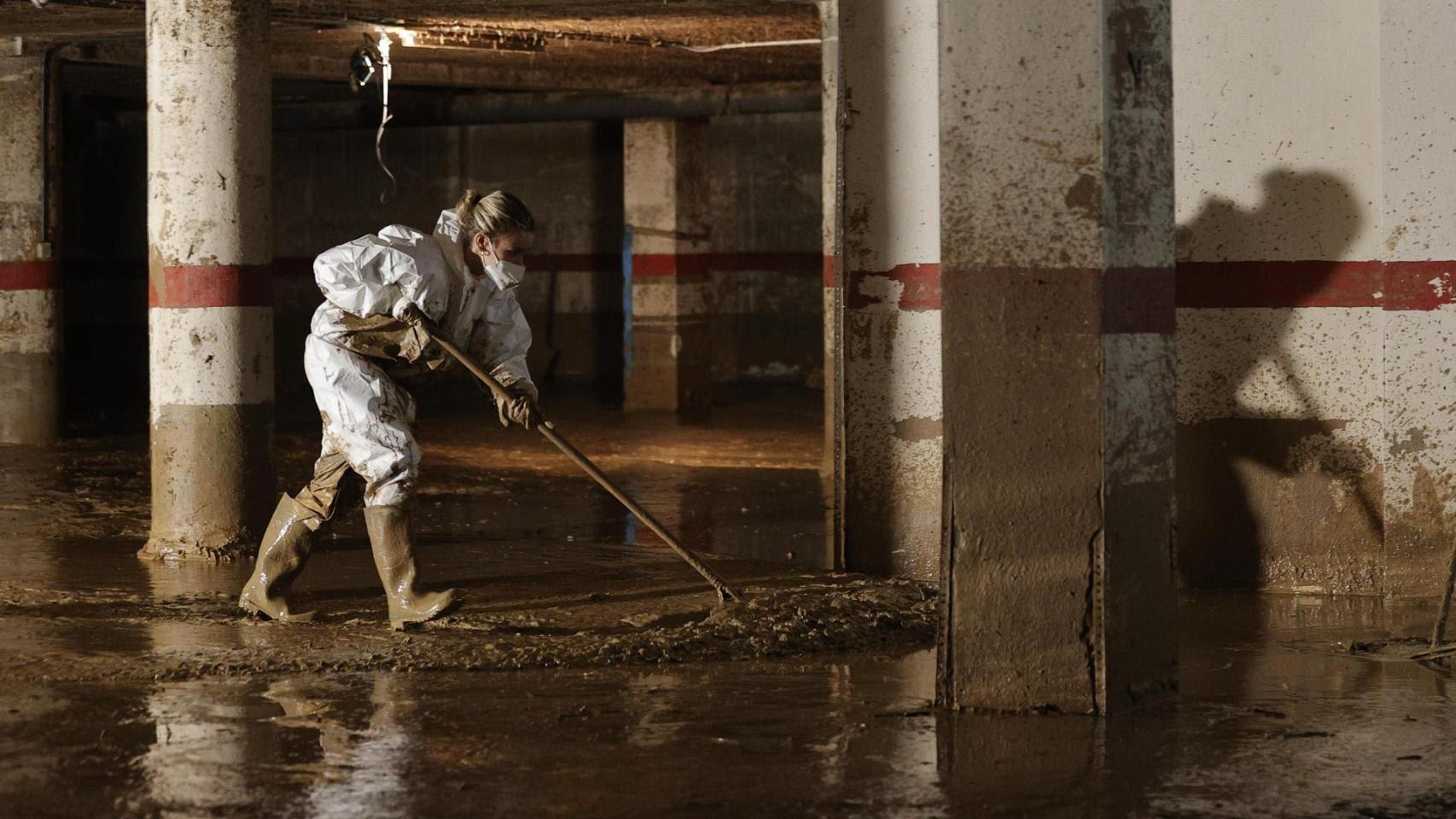 Una voluntaria limpiando un garaje afectado por las inundaciones de la dana. Foto: Efe/ Manuel Bruque