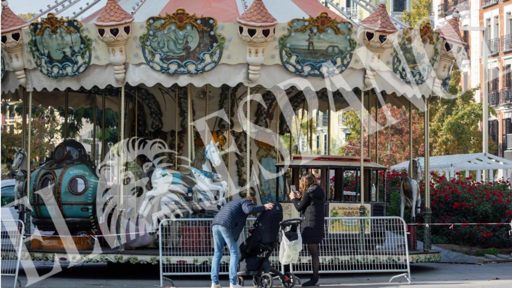 El juez Pedraz y Elena Hormigos junto a su hijo frente a un carrusel de la capital.