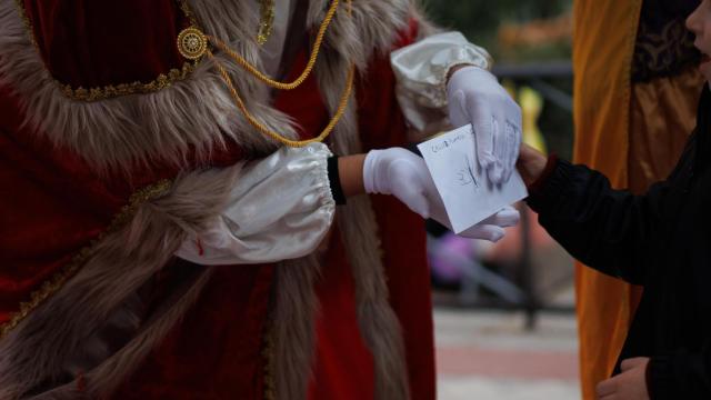 Imagen de un niño entregándole una carta al Rey Mago