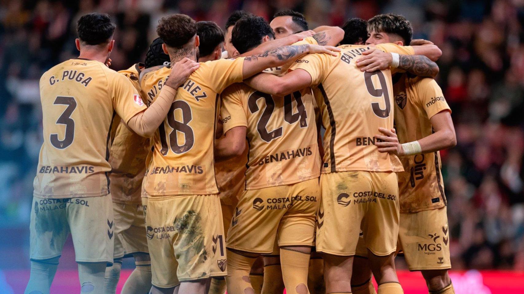 Los jugadores del Málaga celebran un gol en El Molinón.