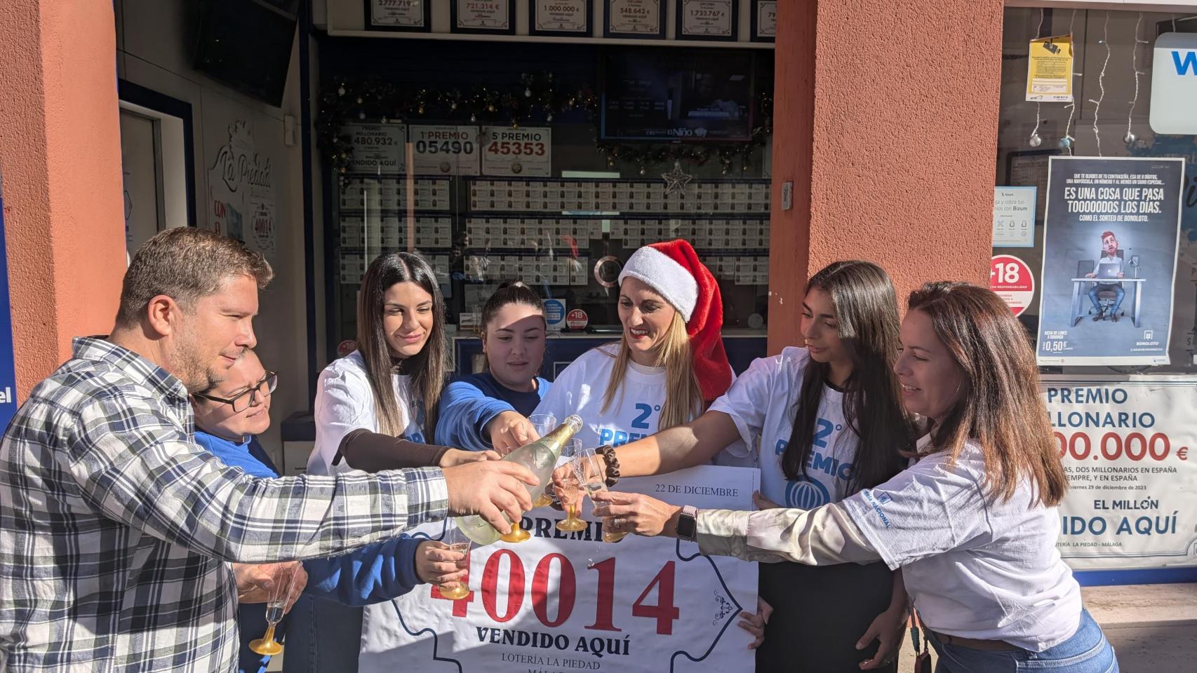 Un brindis por el segundo premio de la Lotería de Navidad en el barrio de El Molinillo, en Málaga.