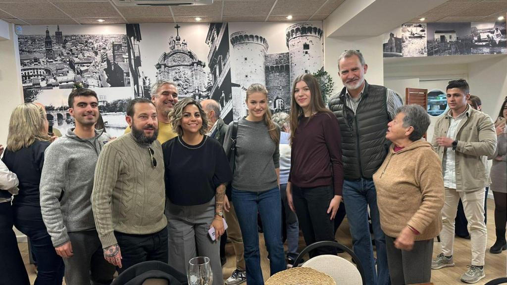 Los reyes Felipe y Letizia, junto a sus hijas, la princesa Leonor y la infanta Sofía, posan junto algunos vecinos, en el restaurante Albufera, en El Palmar (Valencia).