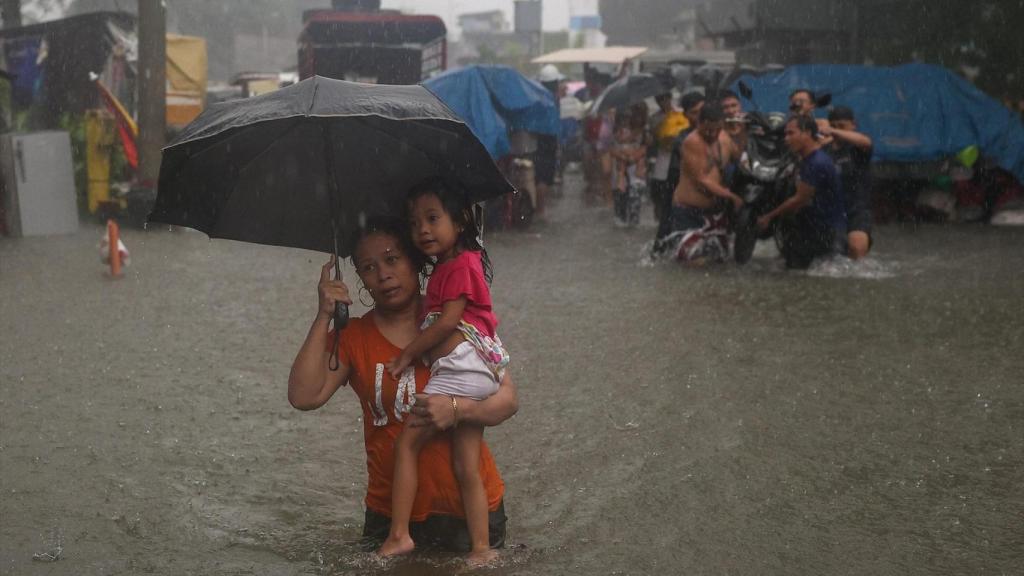 Una mujer poniéndose a salvo con su hija durante los tifones de Filipinas.